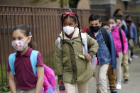 FILE - In this April 29, 2021, file photo, students line up to enter Christa McAuliffe School in Jersey City, N.J. Children are having their noses swabbed or saliva sampled at school to test for the coronavirus. As more children return to school buildings this spring, widely varying approaches have emerged on how and whether to test students and staff members for the virus. (AP Photo/Seth Wenig, File)