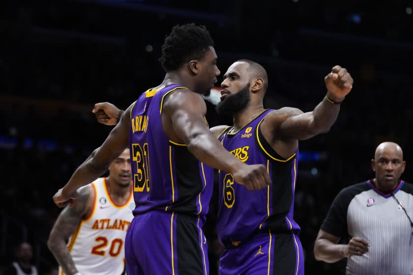 Los Angeles Lakers' Thomas Bryant (31) and LeBron James (6) celebrate after Bryant scored a basket.