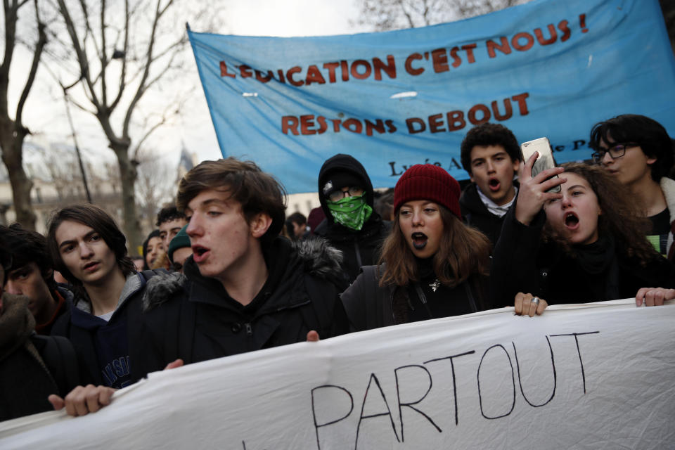 Students opposing changes in key high school tests demonstrate with a banner reading "We are education" Tuesday Dec.11, 2018 in Paris. French President Emmanuel Macron has acknowledged he's partially responsible for the anger that has fueled weeks of protests in France, an unusual admission for the leader elected last year. (AP Photo/Christophe Ena)