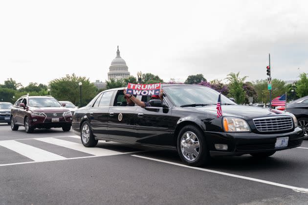 Trump supporters ride in a replica of the presidential limousine outside the courthouse.