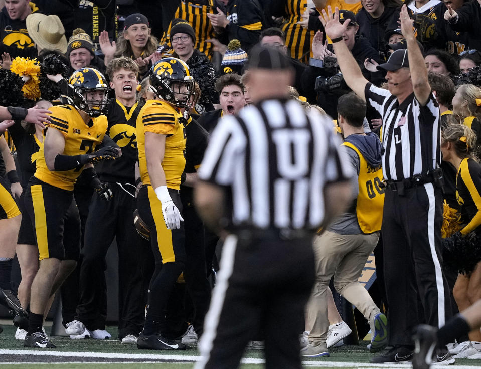 Iowa defensive back Cooper DeJean (3) celebrates with defensive back John Nestor (7) after returning a punt as an official, right, signals a touchdown during the second half of an NCAA college football game against Minnesota, Saturday, Oct. 21, 2023, in Iowa City, Iowa. DeJean's touchdown was called back upon official review. (AP Photo/Matthew Putney)