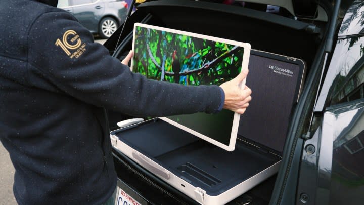 A man adjusts the 27-inch monitor of an LG StanbyMe Go.