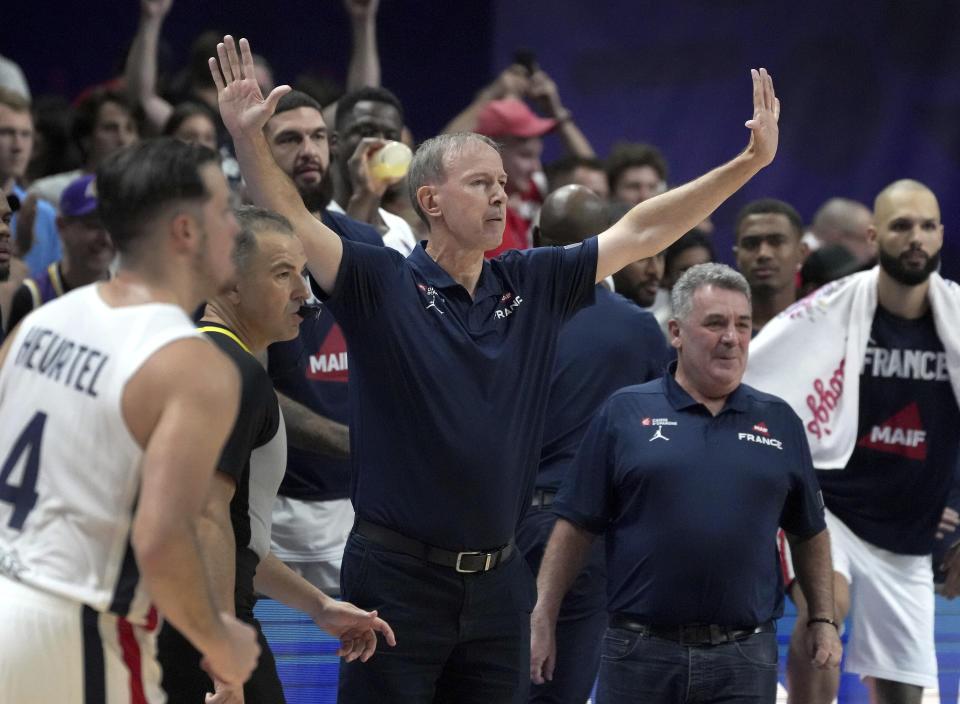 Vicent Collet head coach of France, center, and his team celebrate after the Eurobasket quarter final basketball match between France and Italy in Berlin, Germany, Wednesday, Sept. 14, 2022. France defeated Italy by 93-85. (AP Photo/Michael Sohn)