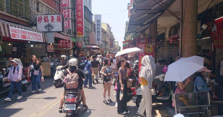 中央氣象署21日將台南市列橙燈高溫警告，市區假日出現的遊客潮紛紛撐傘遮陽。（圖／中國時報記者程炳璋攝）