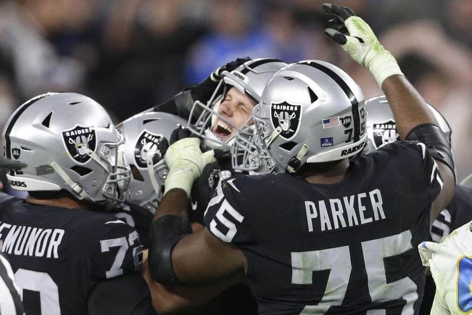 Las Vegas Raiders kicker Daniel Carlson, center, celebrates after kicking the game-winning field goal against the Los Angeles Chargers during overtime of an NFL football game, Sunday, Jan. 9, 2022, in Las Vegas. (AP Photo/Ellen Schmidt)