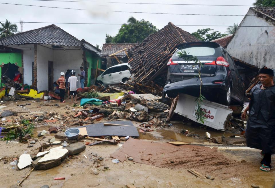 People inspect the damage at a tsunami-ravaged neighborhood in Carita, Indonesia, Sunday, Dec. 23, 2018. The tsunami occurred after the eruption of a volcano around Indonesia's Sunda Strait during a busy holiday weekend, sending water crashing ashore and sweeping away hotels, hundreds of houses and people attending a beach concert. (AP Photo) ORG XMIT: XJAK118