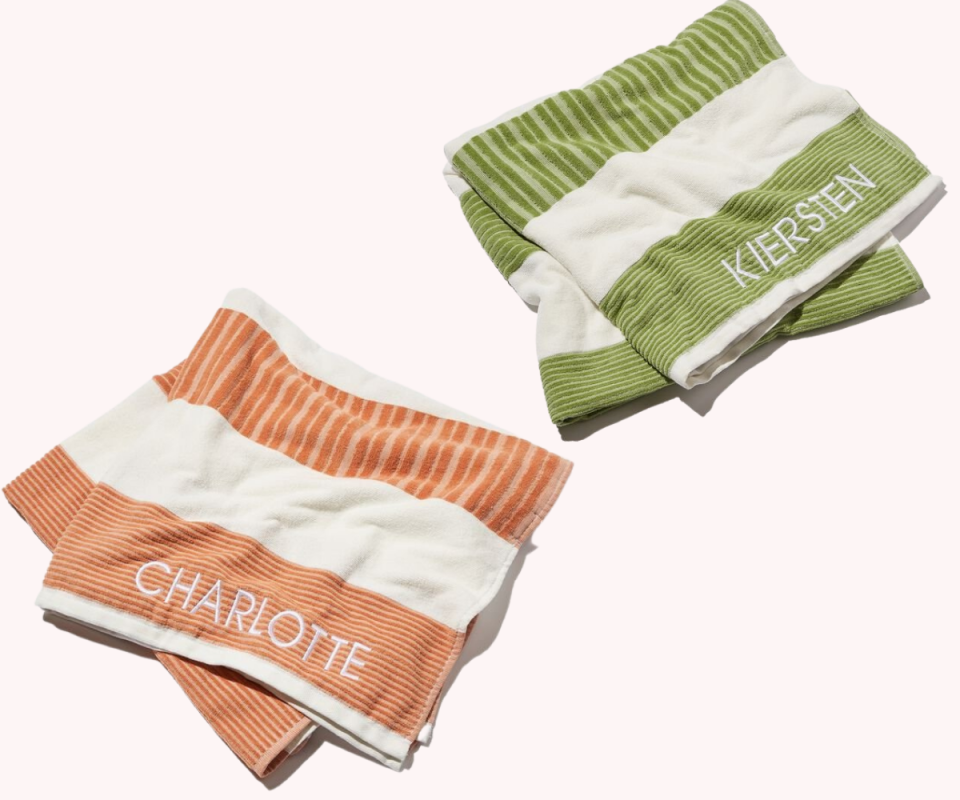 On the left, an apricot and cream striped towel is folded with Charlotte written on the bottom. On the top right is an olive and cream striped towel with the word Kiersten on the bottom, both on a cream background..