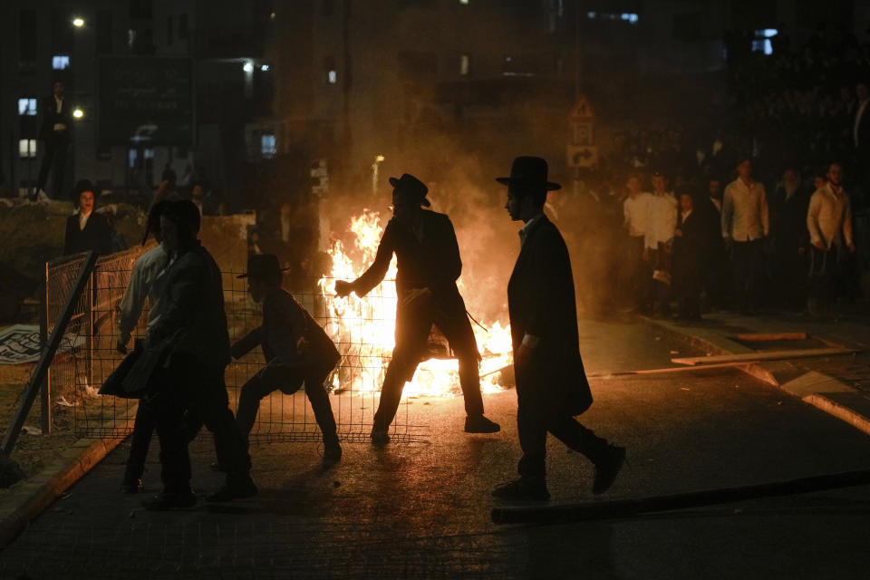 Ultra-Orthodox Jewish men burn trash during a protest against army recruitment in Jerusalem on Sunday, June 30, 2024. Israel's Supreme Court last week ordered the government to begin drafting ultra-Orthodox men into the army, a landmark ruling seeking to end a system that has allowed them to avoid enlistment into compulsory military service. (AP Photo/Ohad Zwigenberg)