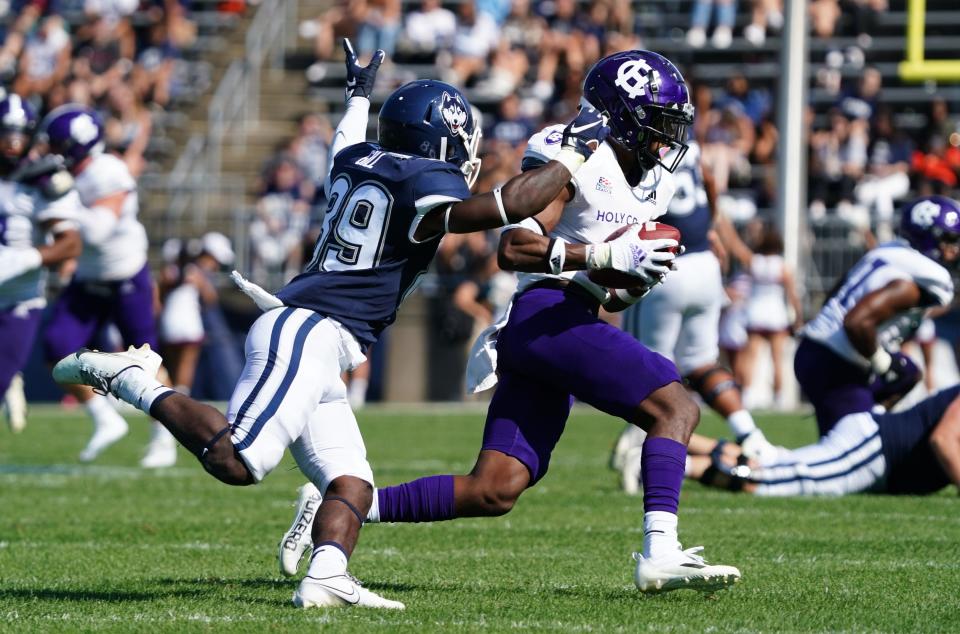 Holy Cross defensive back John Smith intercepts a pass intended for Connecticut wide receiver Jahkai Gill.