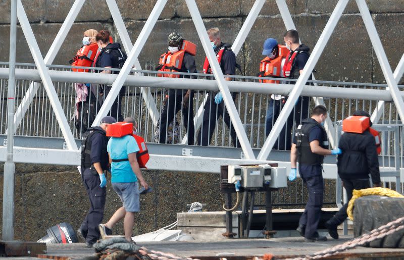 Migrants disembark after arriving at Dover harbour, in Dover