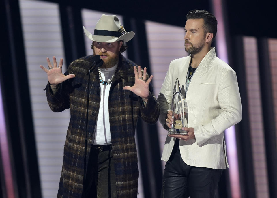 John Osborne, left, and T.J. Osborne, of Brothers Osborne, accept the award for vocal duo of the year at the 55th annual CMA Awards on Wednesday, Nov. 10, 2021, at the Bridgestone Arena in Nashville, Tenn. (AP Photo/Mark Humphrey)