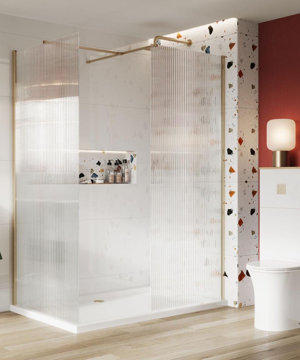 large shower with terrazzo patterned shower niche and walls and fluted shower panel