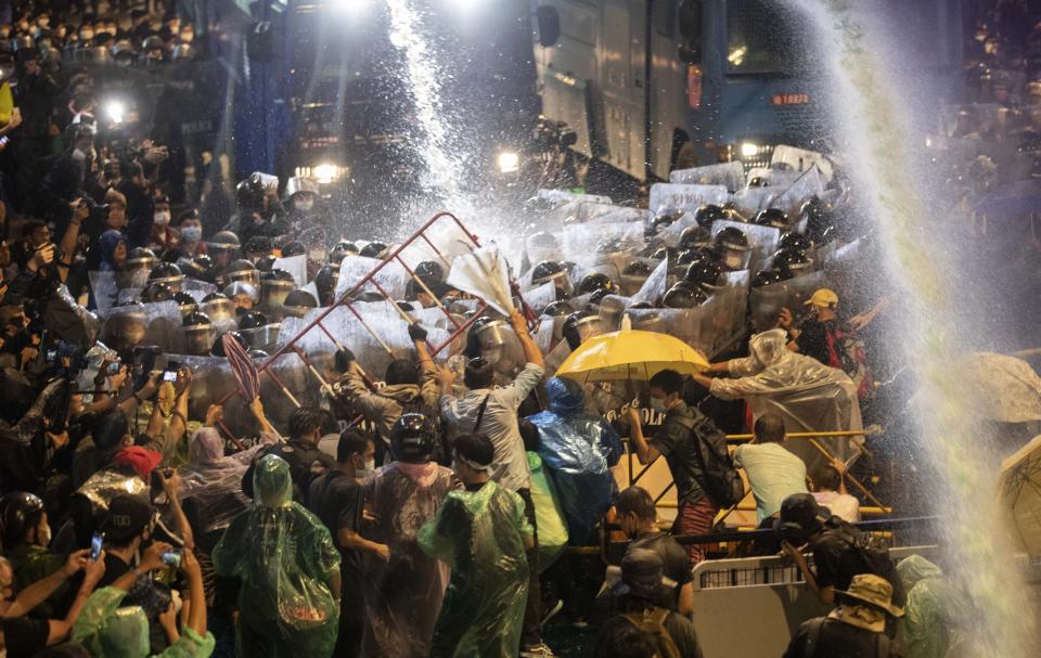 Pro democracy demonstrators face water canons as police try to disperse them from their protest venue in Bangkok, Thailand, Friday, Oct. 16, 2020. Thailand prime minister has rejected calls for his resignation as his government steps up efforts to stop student-led protesters from rallying in the capital for a second day in defiance of a strict state of emergency. (AP Photo/Gemunu Amarasinghe)