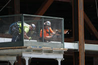 Workers build a protective railing as construction continued on the New York Islanders' new arena, located adjacent to Belmont race track, Wednesday, May 27, 2020, in Elmont, New York. Long Island became the latest region of New York to begin easing restrictions put in place to curb the spread of the coronavirus as it enters the first phase of the state's four-step reopening process. Gov. Andrew Cuomo announced Tuesday that Nassau and Suffolk counties could begin reopening parts of their economy after non-essential businesses were shuttered for two months. (AP Photo/Kathy Willens)
