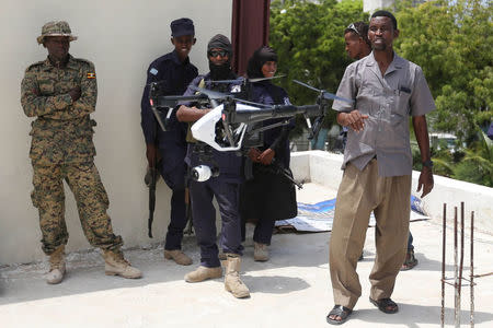 Somali police officers watch a DJI Inspire drone hover during a drone training session for Somali police in Mogadishu, Somalia May 25, 2017. Picture taken May 25, 2017. REUTERS/Feisal Omar