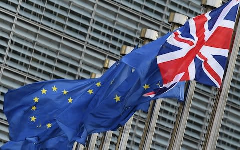 A Union Jack flag flies next to European Union flags in front of the European Commission building  - Credit: AFP/EMMANUEL DUNAND