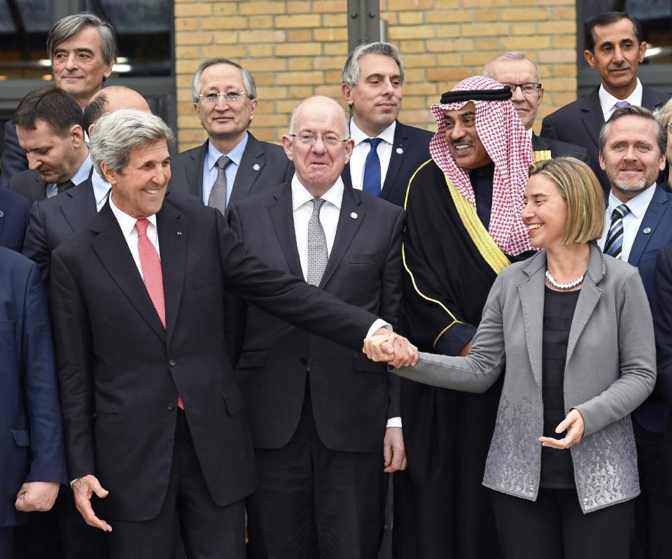 US Secretary of State John Kerry shares a laugh with European Union Foreign Policy Chief Federica Mogherini, right, as they take part with other foreign ministers and representatives in a family picture during a Mideast peace conference in Paris, Sunday, Jan. 15, 2017. Fearing a new eruption of violence in the Middle East, more than 70 world diplomats gathered in Paris on Sunday to push for renewed peace talks that would lead to a Palestinian state. (Bertrand Guay/Pool Photo via AP)