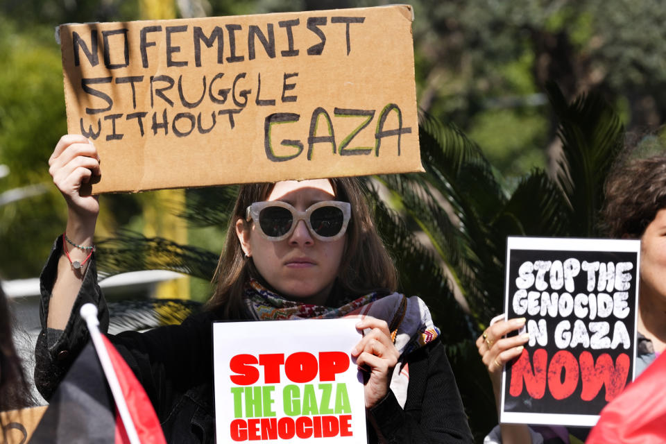 A Lebanese woman holds placards as she attends a protest to support the Palestinian women on the International Women's Day outside the office of a U.N. organisation, in Beirut, Lebanon, Friday, March 8, 2024. The U.N. agency for Palestinian refugees says about 9,000 women have been killed in the Gaza Strip since the Israel-Hamas war began five months ago. (AP Photo/Hussein Malla)