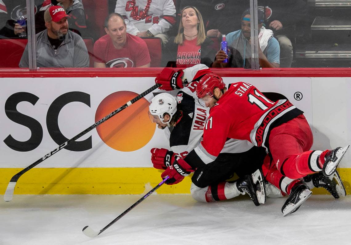 The Carolina Hurricanes Jordan Staal (11) checks the New Jersey Devils Erik Haula (56) into the boards in the third period during Game 2 of their second round Stanley Cup playoff series on Friday, May 5, 2023 at PNC Arena in Raleigh, N.C.