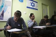 Newly arrived immigrants from France (from L to R) Jonathan Arbibe and Samuel Chemama and Alexandre Pequito, both of whom are from Paris, study Hebrew at Ulpan Etzion, the original residential school and absorption centre, which has taught Hebrew to tens of thousands of immigrants since 1949, in Jerusalem January 20, 2015. REUTERS/Ronen Zvulun