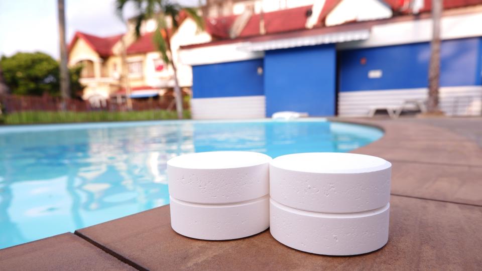 Pool cleaning tablets next to a pool