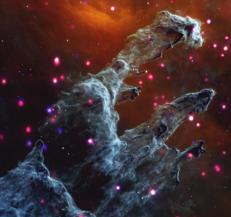 pillars of creation eagle nebula textured fingers of blue-grey clouds in space with bright pink stars in the background and foreground