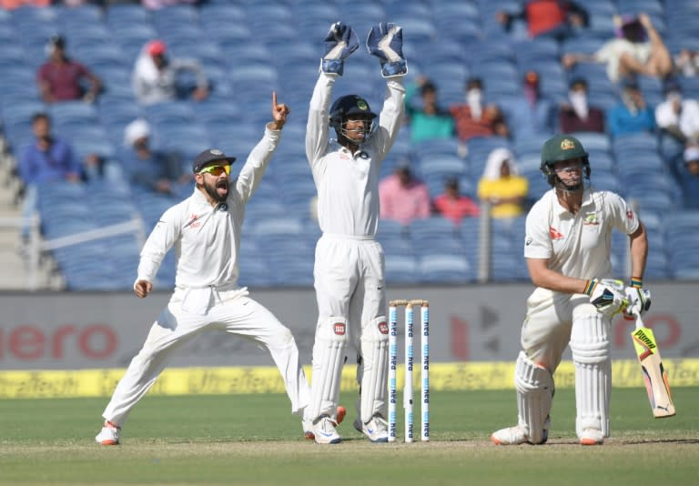 India's captain Virat Kohli (left) and Wriddhiman Saha appeal unsuccessfully against Australia's Mitchell Marsh during the second day of their first Test match in Pune on February 24, 2017