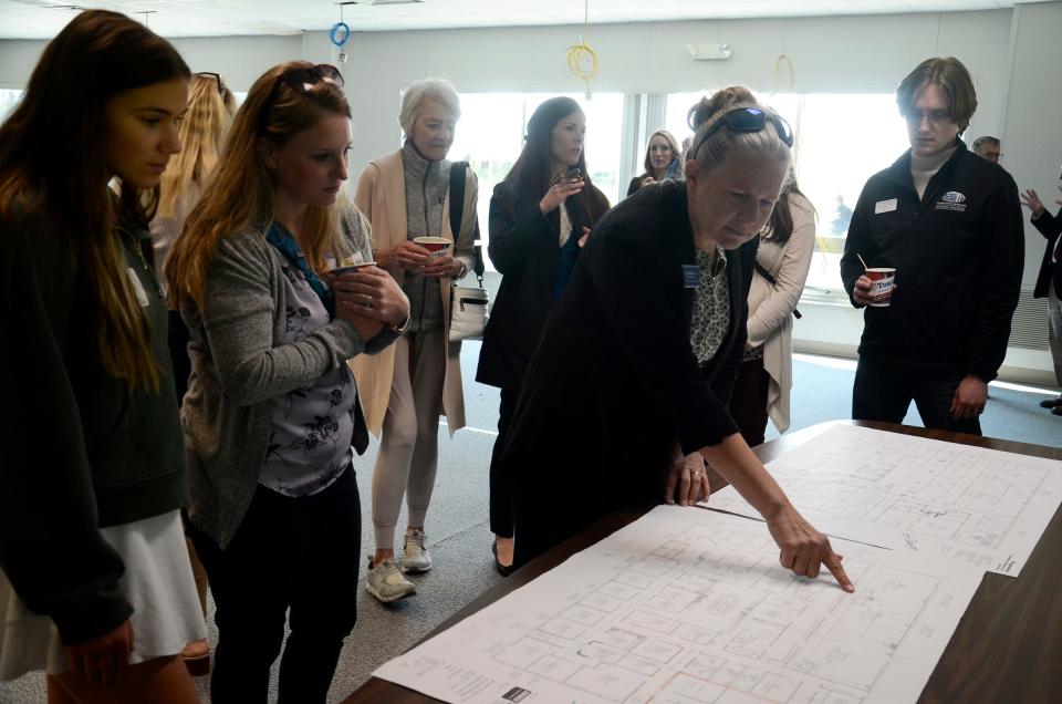 Gail Kloss, executive director of the Women’s Resource Center of Northern Michigan, points out details on the blueprint of their Empowering Bright Futures initiative on Tuesday, May 14, 2024 during their groundbreaking ceremony.