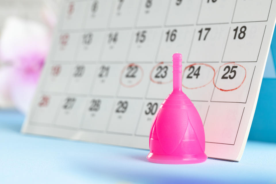 Calendar page and menstrual cup close up on table