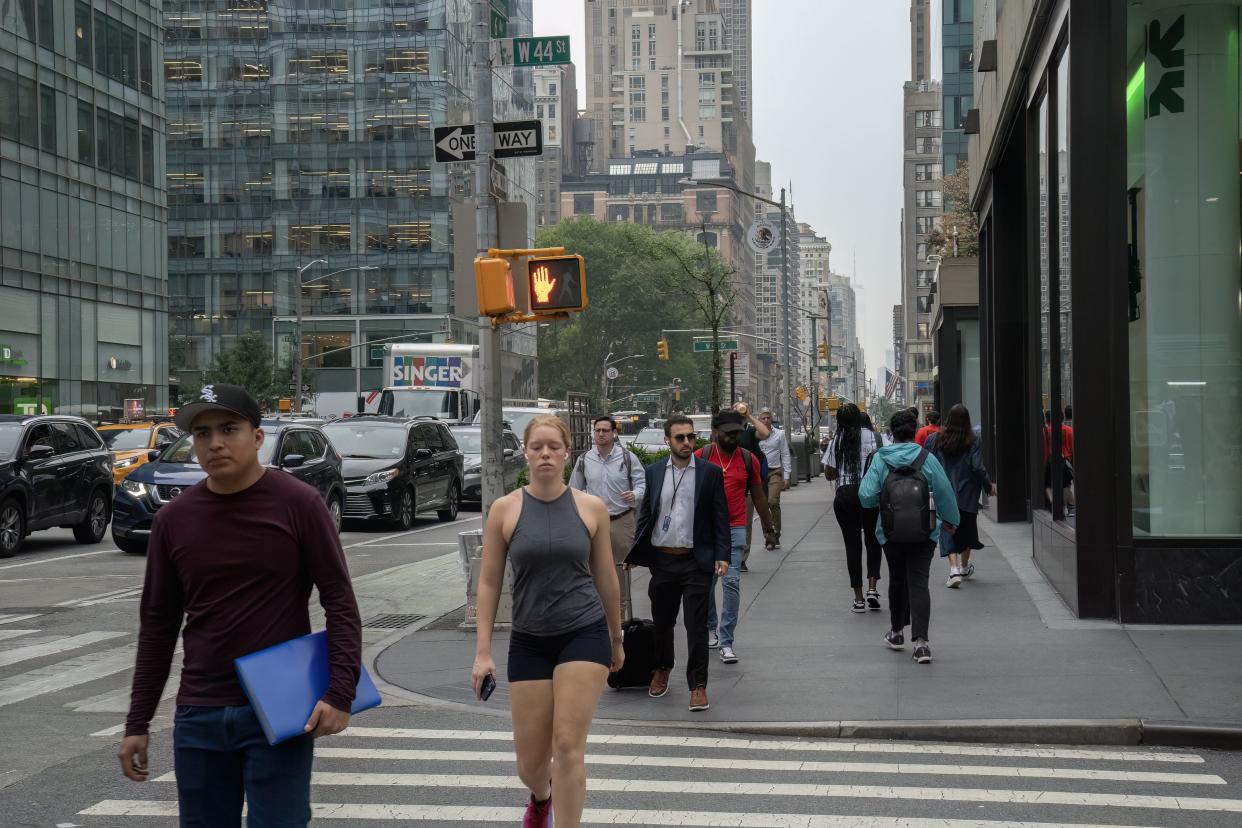 New York, USA - July 20th, 2023: Pedestrians jaywalking on a signaled road crossing, while the signal is red.