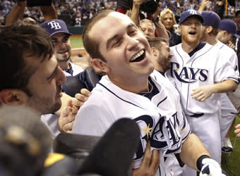 The Rays mobbed Evan Longoria after his game-winning home run on Wednesday. Dan Johnson (right) had kept Tampa Bay alive with a home run of his own in the ninth inning