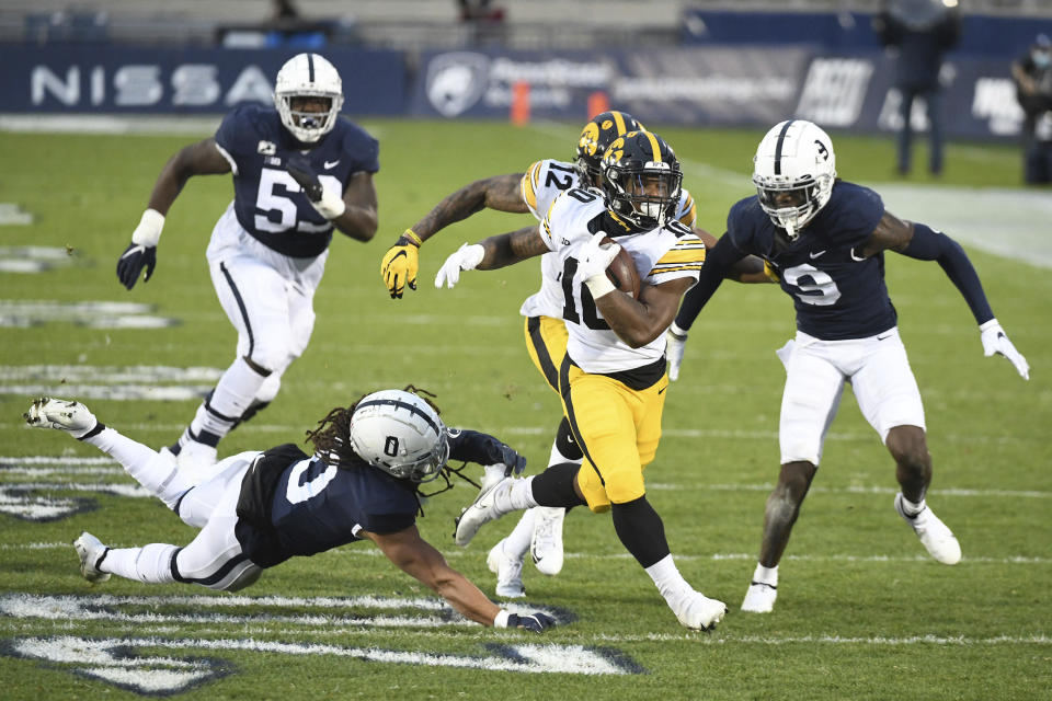 Iowa running back Mekhi Sargent (10) breaks a tackle attempt by Penn State safety Jonathan Sutherland (0) during the first quarter of an NCAA college football game in State College, Pa., on Saturday, Nov. 21, 2020. (AP Photo/Barry Reeger)