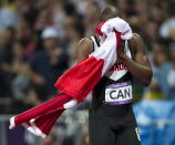 Canada's Oluseyi Smith cries into a flag after the Canadian relay team had their third place finish disqualified in the men's 4x100 metre final at the 2012 Summer Olympics in London, Saturday, August 11, 2012.THE CANADIAN PRESS/Ryan Remiorz