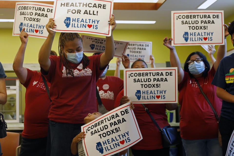 Members of Health Illinois coalition celebrate the extension of state health insurance coverage to older immigrants, ages 55 and over, living in the country illegally, Tuesday, July 20, 2021, in Chicago's Pilsen neighborhood. The state was the first nationwide to offer a Medicaid-like program for immigrant seniors last year and used this year's budget to expand the program. (AP Photo/Shafkat Anowar)