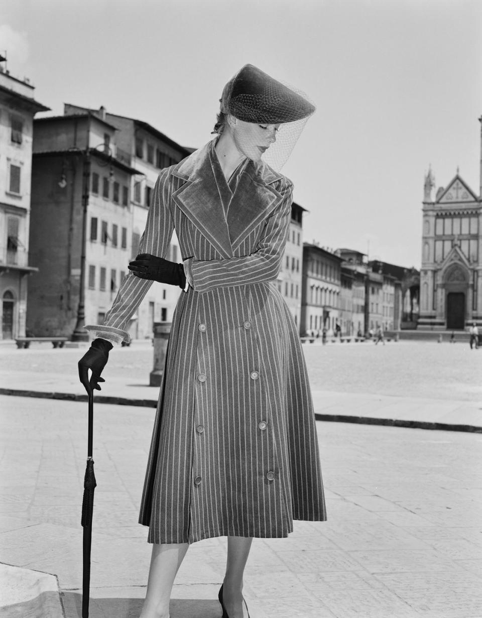 <p>An Italian model wearing a tailored corduroy trench with wide lapels and a veiled visor hat.</p>