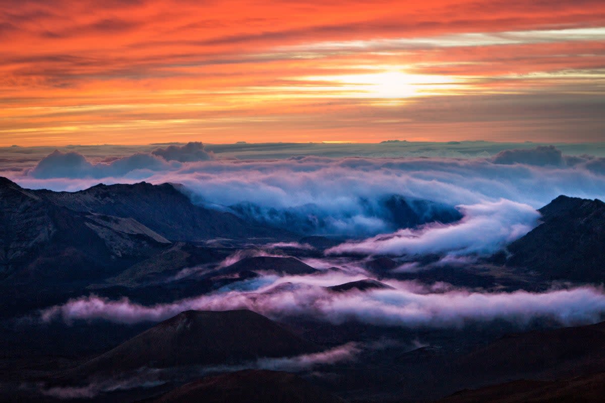 Watch the sun rise above the clouds at the Haleakala Volcano, 10,000 feet above sea level (Getty Images)