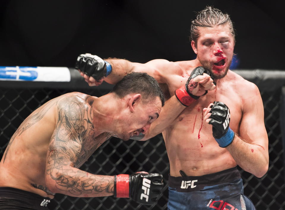 Max Holloway, left, fights Brian Ortega during the featherweight championship mixed martial arts bout at UFC 231 in Toronto on Saturday, Dec. 8, 2018. (Nathan Denette/The Canadian Press via AP)