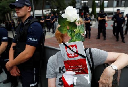 Woman holds copy of Polish constitution as she takes part in an anti-government protest in support of free courts outside the Parliament building in Warsaw July 18, 2018. REUTERS/Kacper Pempel