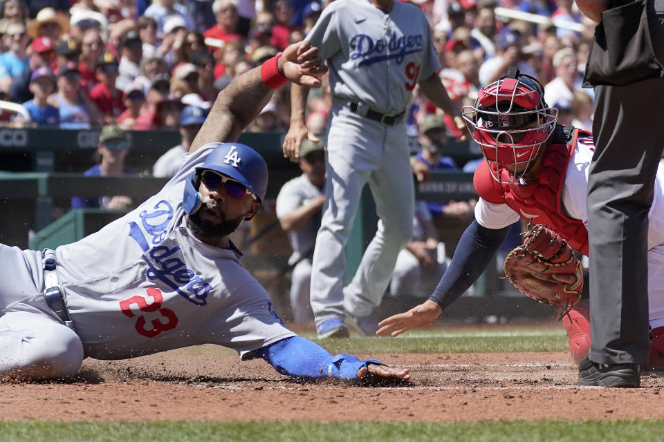 Los Angeles Dodgers' Jason Heyward (23) avoids the tag from St. Louis Cardinals catcher Willson Contreras, right, to score during the fifth inning of a baseball game Sunday, May 21, 2023, in St. Louis. (AP Photo/Jeff Roberson)