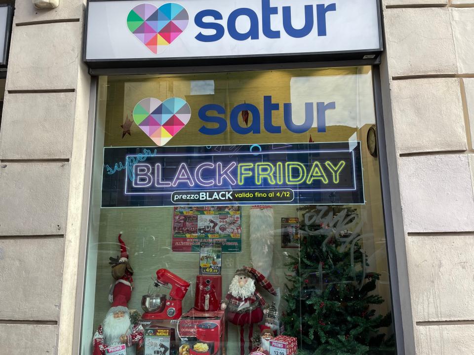 exterior shot of a satur store in rome italy with black friday sale signs in the window