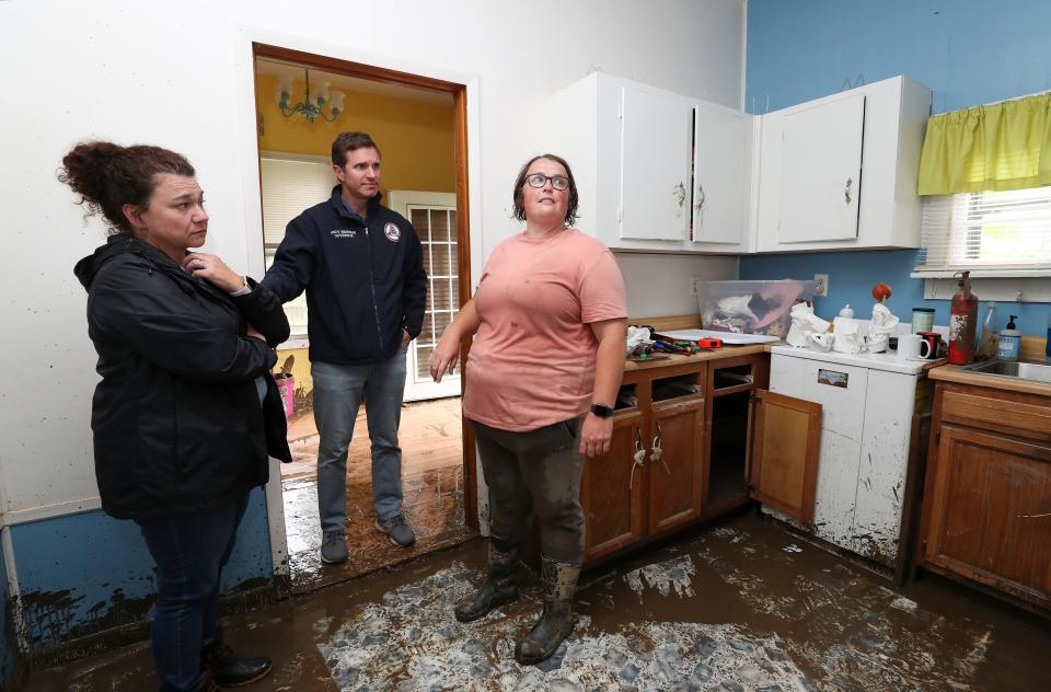 Gov. Andy Beshear, center, visits the home of Elisa Cook, right, with state Rep. Angie Hatton following the widespread destruction caused by flooding in Whitesburg, Ky. on July 31, 2022.