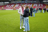 Wrexham Co-Owner Rob McElhenney, left, chats on the pitch after the English League Two soccer match between Wrexham and Stockport at the Racecourse Ground Stadium in Wrexham, Wales, Saturday, April 27, 2024. Wrexham AFC got promoted to League One.(AP Photo/Jon Super)