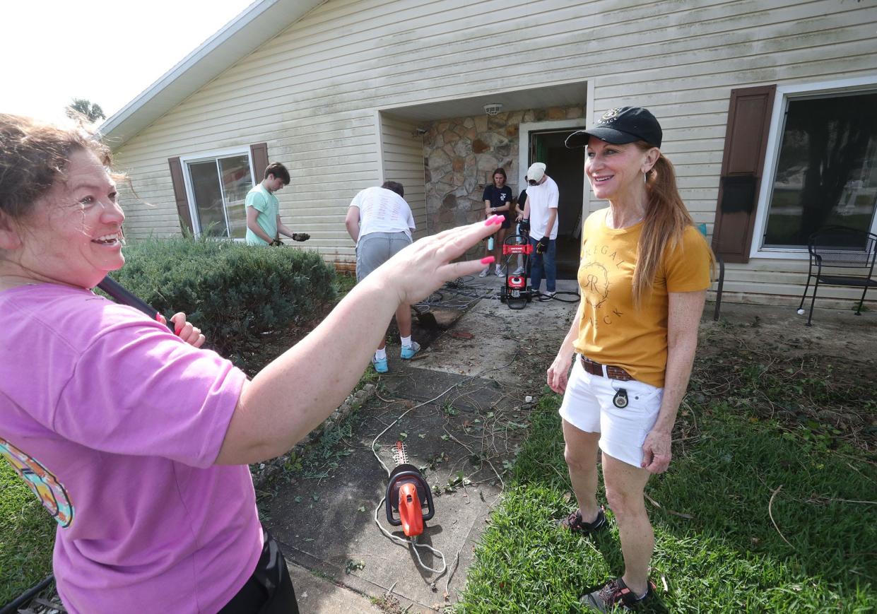 Gwen Wakeman, right, talks with volunteer Kelley Rankin Tuesday in the Port Orange yard of a home owned by Wakeman's mother. The home has been unoccupied since Hurricane Ian flooded it on Sept. 29, 2022, and repairs were delayed when a man defrauded the homeowner of more than $50,000, according to a charging affidavit.