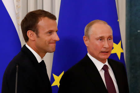 Russian President Vladimir Putin (R) and his French counterpart Emmanuel Macron leave after a news conference in St. Petersburg, Russia May 24, 2018. REUTERS/Grigory Dukor