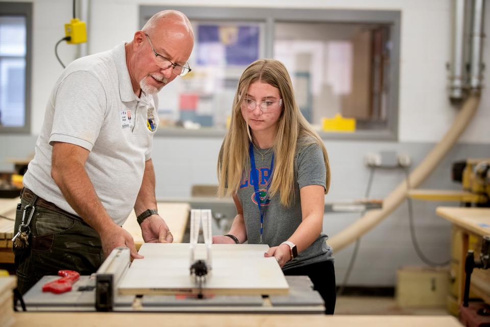 Teacher Jimmy Giles helps Hannah Deese cut a panel on a table saw as students work on construction type assignments in a Cabinet Making/Construction class in the ACE Academy at Bartow High School In Bartow  Fl. Wednesday August 31,2022.The Bartow High School Academy trains students to fill construction jobs amid worker shortage. Labor Day feature on construction worker shortage and efforts to add skilled workers.
Ernst Peters/The Ledger