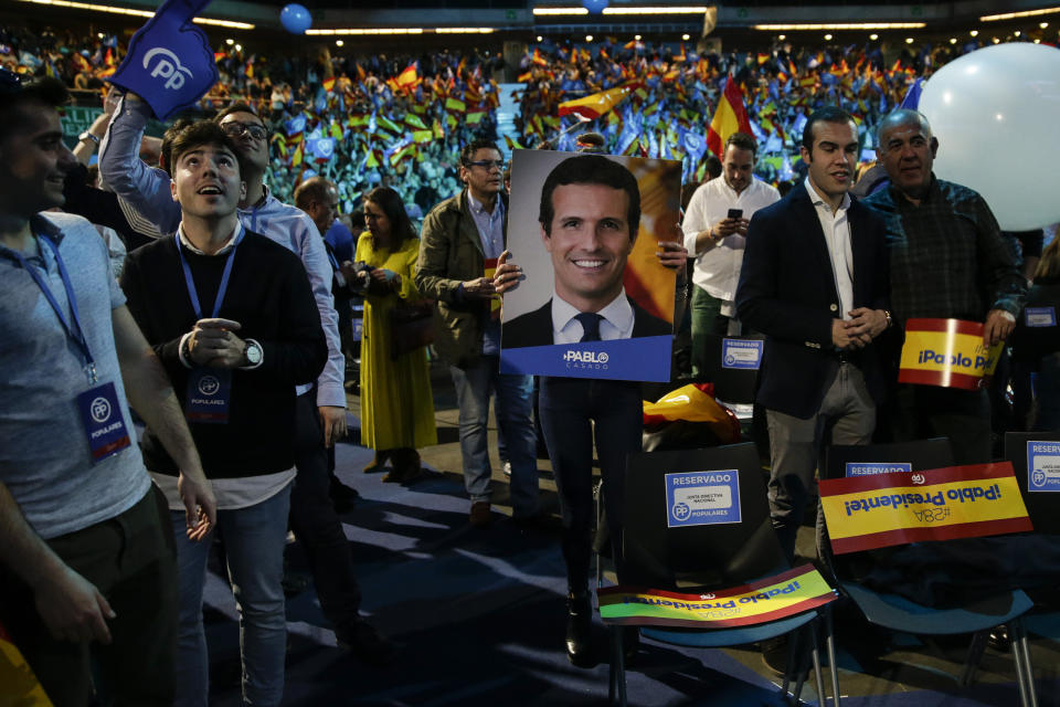 A supporter holds a picture of Popular Party's candidate Pablo Casado during the closing election campaign event in Madrid, Spain, Friday, April 26, 2019. Appealing to Spain's large pool of undecided voters, top candidates on both the right and left are urging Spaniards to choose wisely and keep the far-right at bay in Sunday's general election. (AP Photo/Andrea Comas)