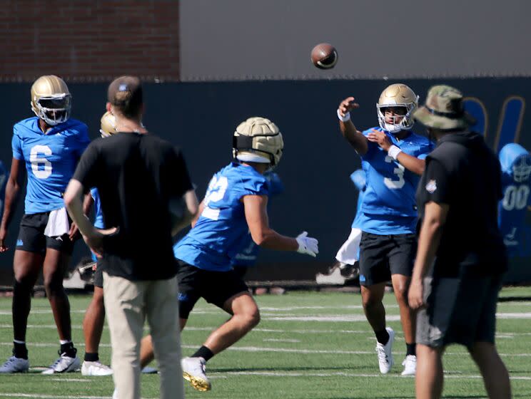 UCLA quarterback Dante Moore (3) warms up by passing the ball during practice