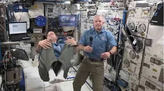 Expedition 41 astronaut Reid Wiseman (left) begins a backflip beside Steve Swanson on the International Space Station. The NASA astronauts were participating in a July 18, 2014 event with actor Morgan Freeman.