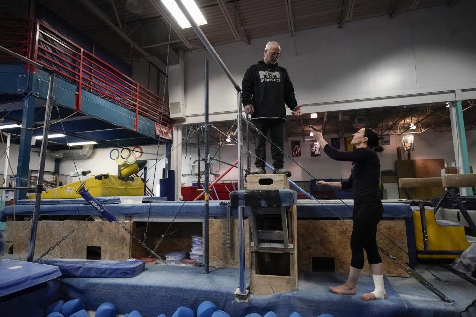 Former gymnastics world champion and Olympic silver medalist Chellsie Memmel works out with her father and coach Andy Memmel Thursday, Feb. 18, 2021, in New Berlin, Wisc. Memmel, 32, rediscovered her love for the sport, so much so the married mother of two is making an unlikely comeback. (AP Photo/Morry Gash)