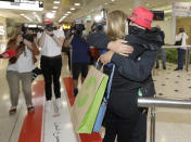 A woman arriving from New Zealand, right, is hugged by her stepmother at Sydney Airport in Sydney, Australia, Monday, April 19, 2021, as the much-anticipated travel bubble between Australia and New Zealand opens. (AP Photo/Rick Rycroft)